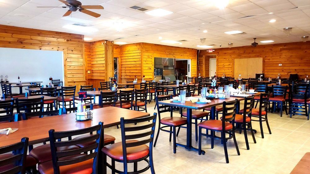 The wood-paneled dining room with red-seat chairs
